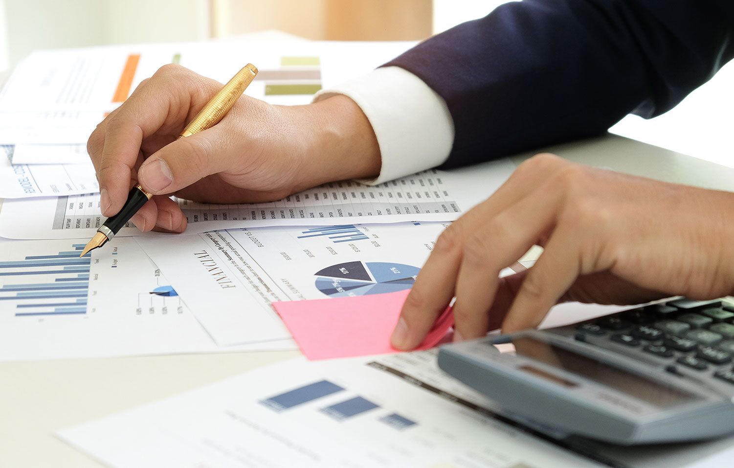 man looking at graphs and using a calculator