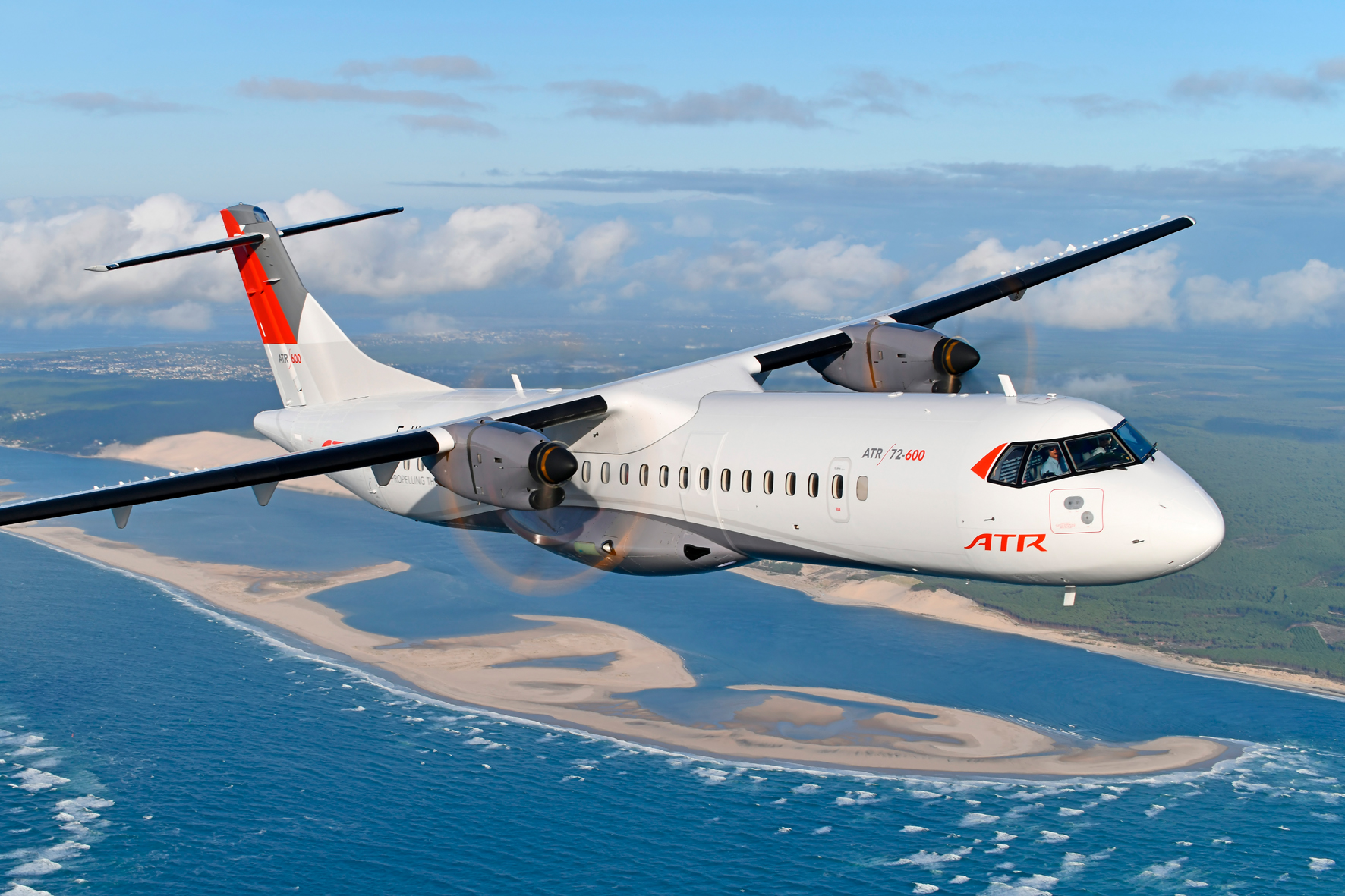 ATR airplane in sky with ocean in background